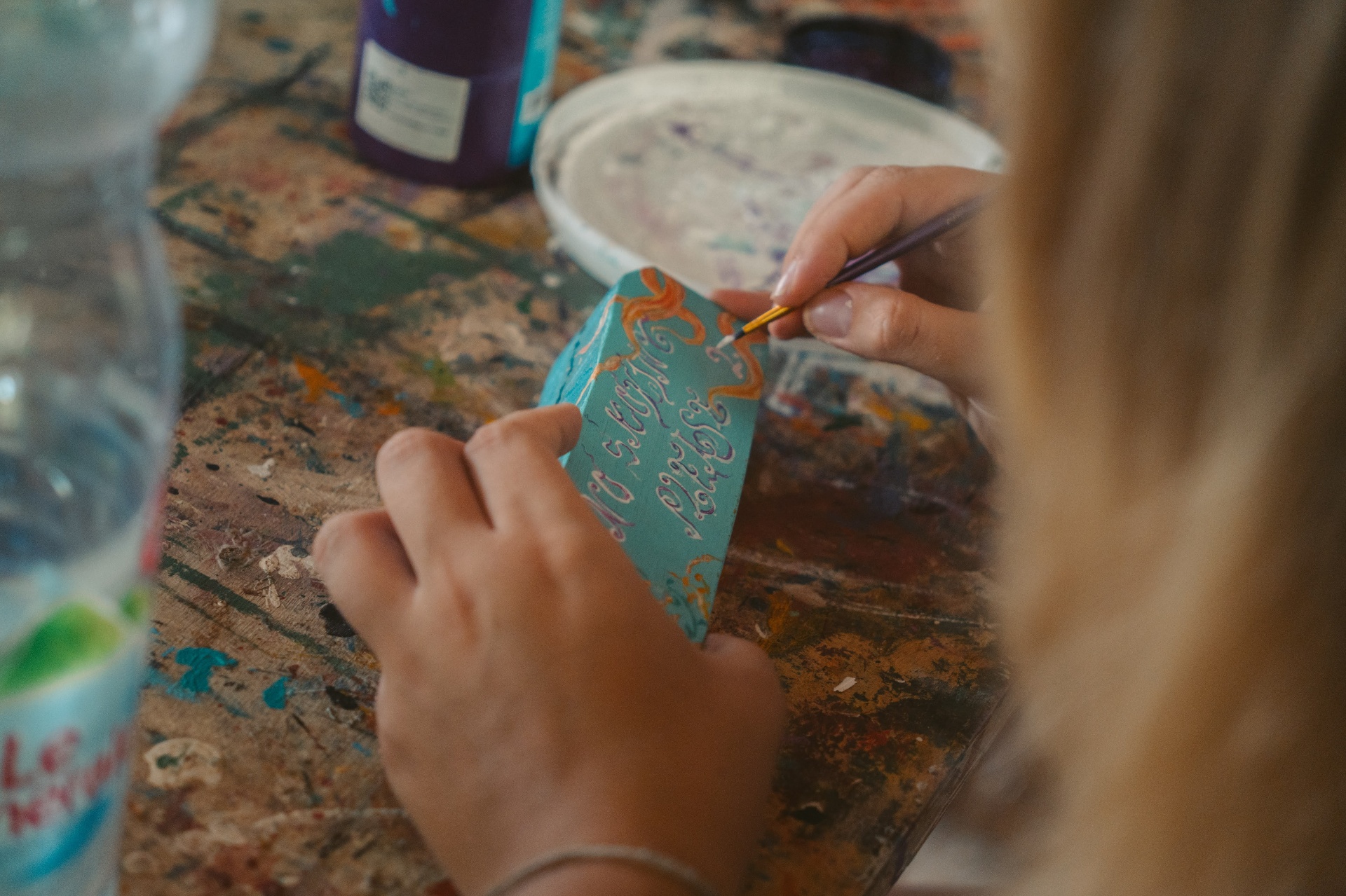 A close-up of detailed hand painting work on a small object at Wonderland.